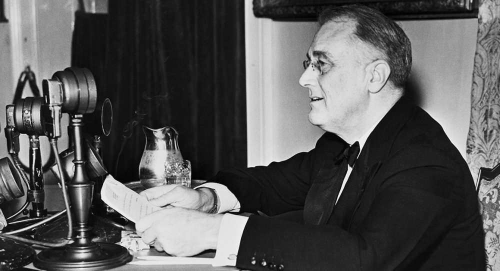 When did President Franklin D. Roosevelt first use the phrase “Arsenal of Democracy” in a radio speech to famously describe the U.S. war industry?